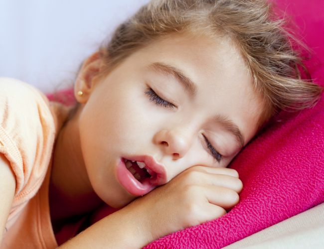 Deep sleeping children girl closeup portrait on pink pillow
